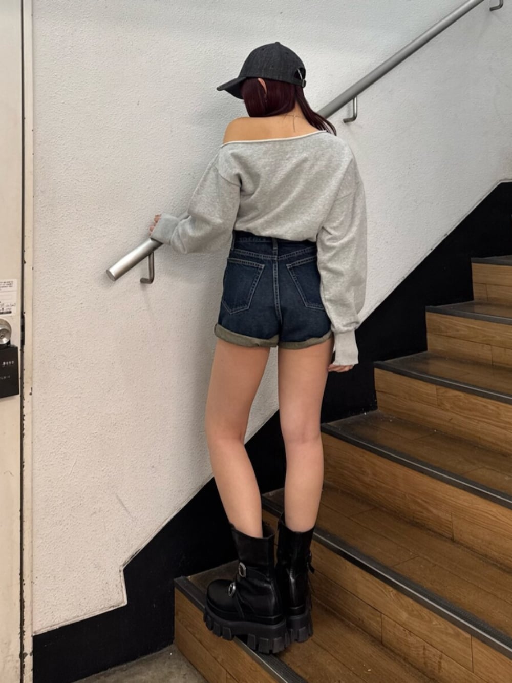 ブラック系のブーツ、グレー系のスウェット、ブルー系のデニムパンツを着用したレディースの冬コーディネートの3枚目の写真