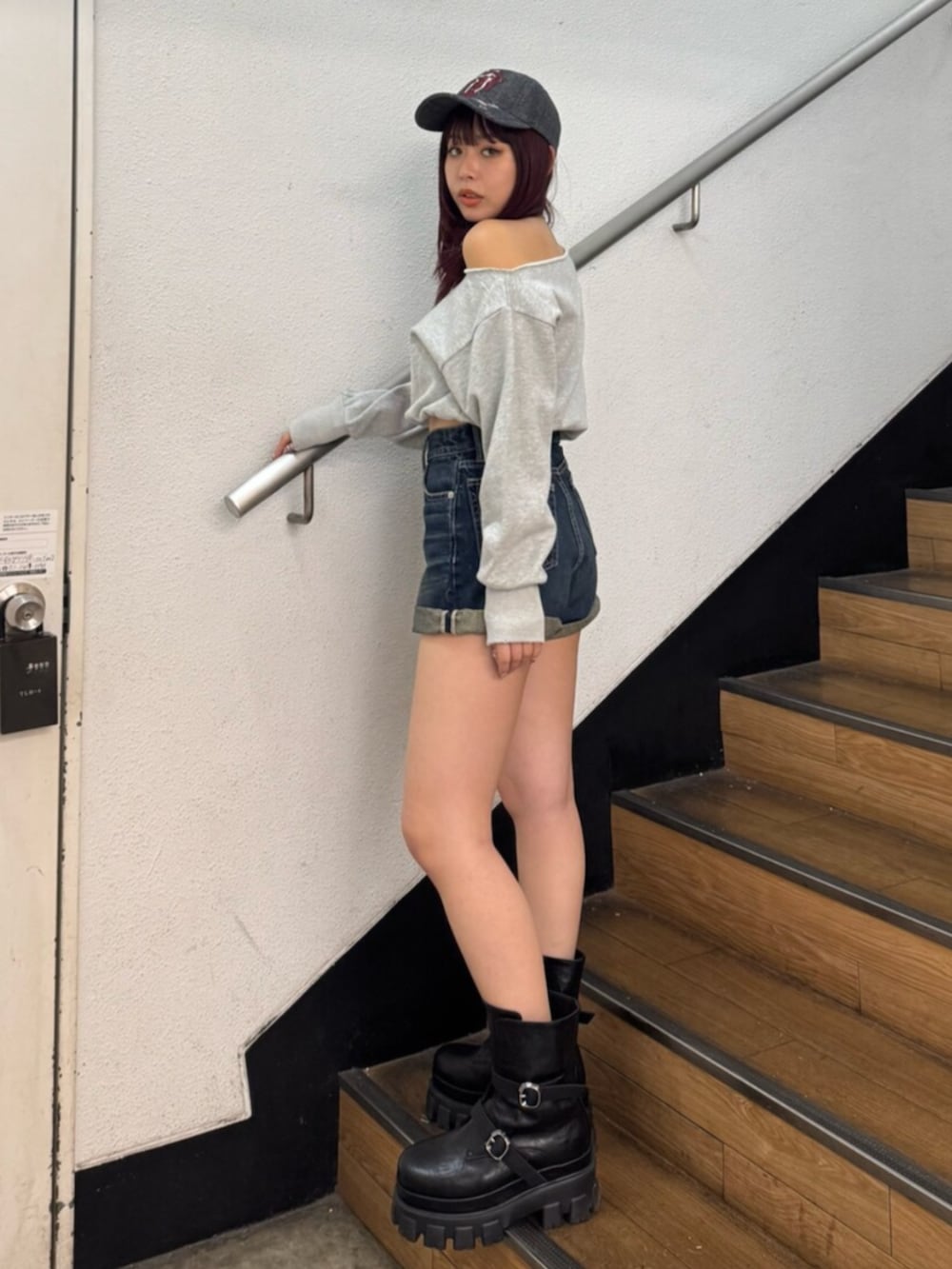 ブラック系のブーツ、グレー系のスウェット、ブルー系のデニムパンツを着用したレディースの冬コーディネートの2枚目の写真