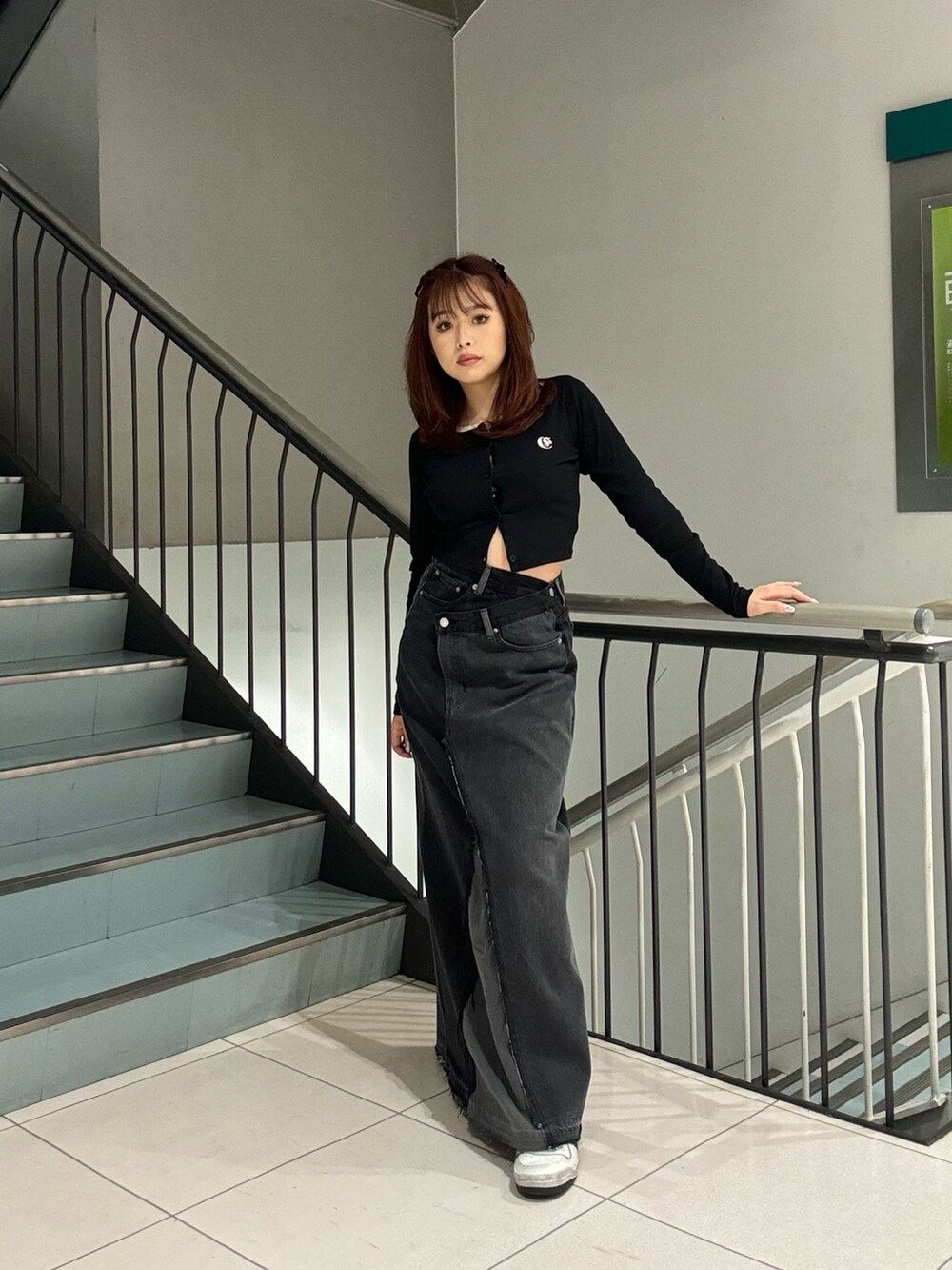 ブラック系のTシャツ/カットソー、ブラック系のデニムスカートを着用したレディースの冬コーディネートの2枚目の写真