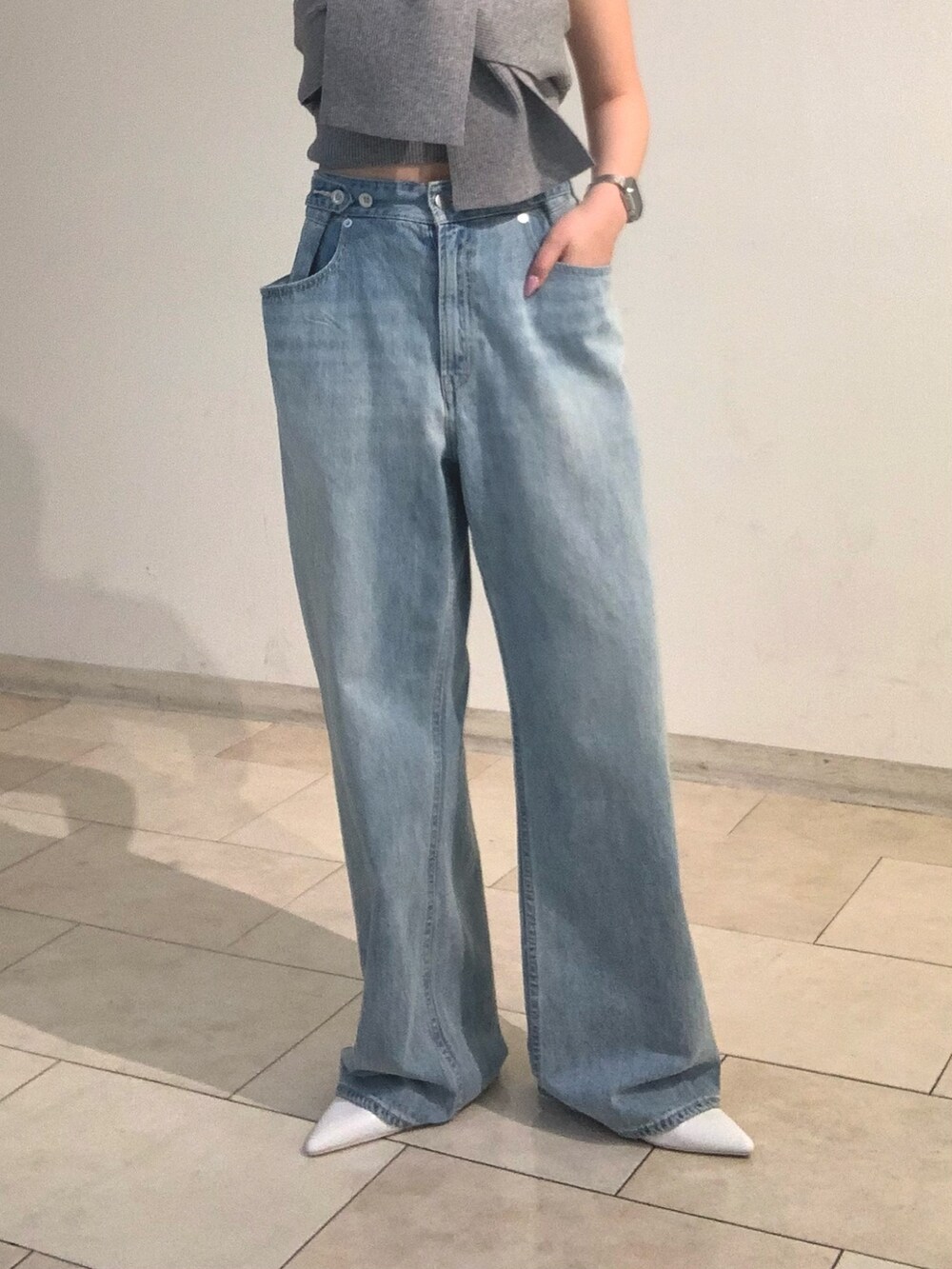 グレー系のチューブトップ、ブルー系のデニムパンツ、シルバー系のショルダーバッグを着用したレディースの春コーディネートの6枚目の写真