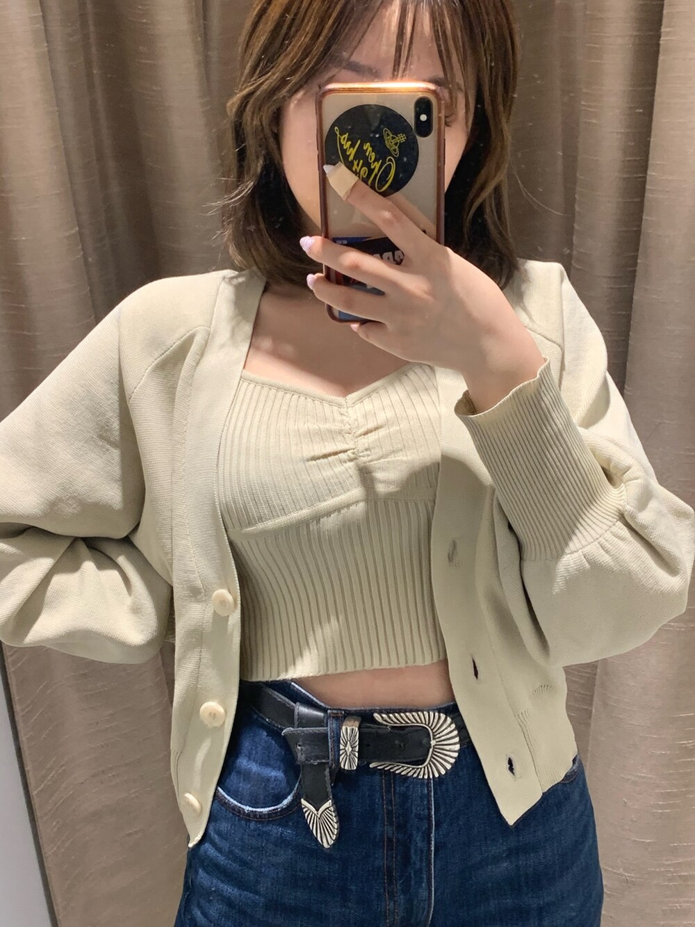 ブルー系のデニムパンツ、ホワイト系のカーディガン/ボレロ、ホワイト系のブーツを着用したレディースの冬コーディネートの2枚目の写真