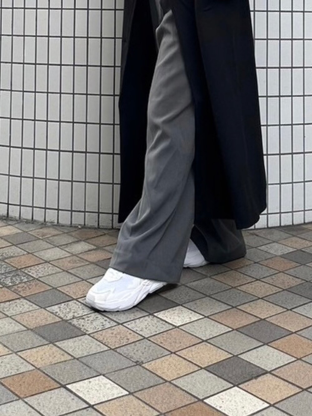 ブラック系のチェスターコート、ホワイト系のパーカー、グレー系のその他パンツを着用したレディースの冬コーディネートの5枚目の写真