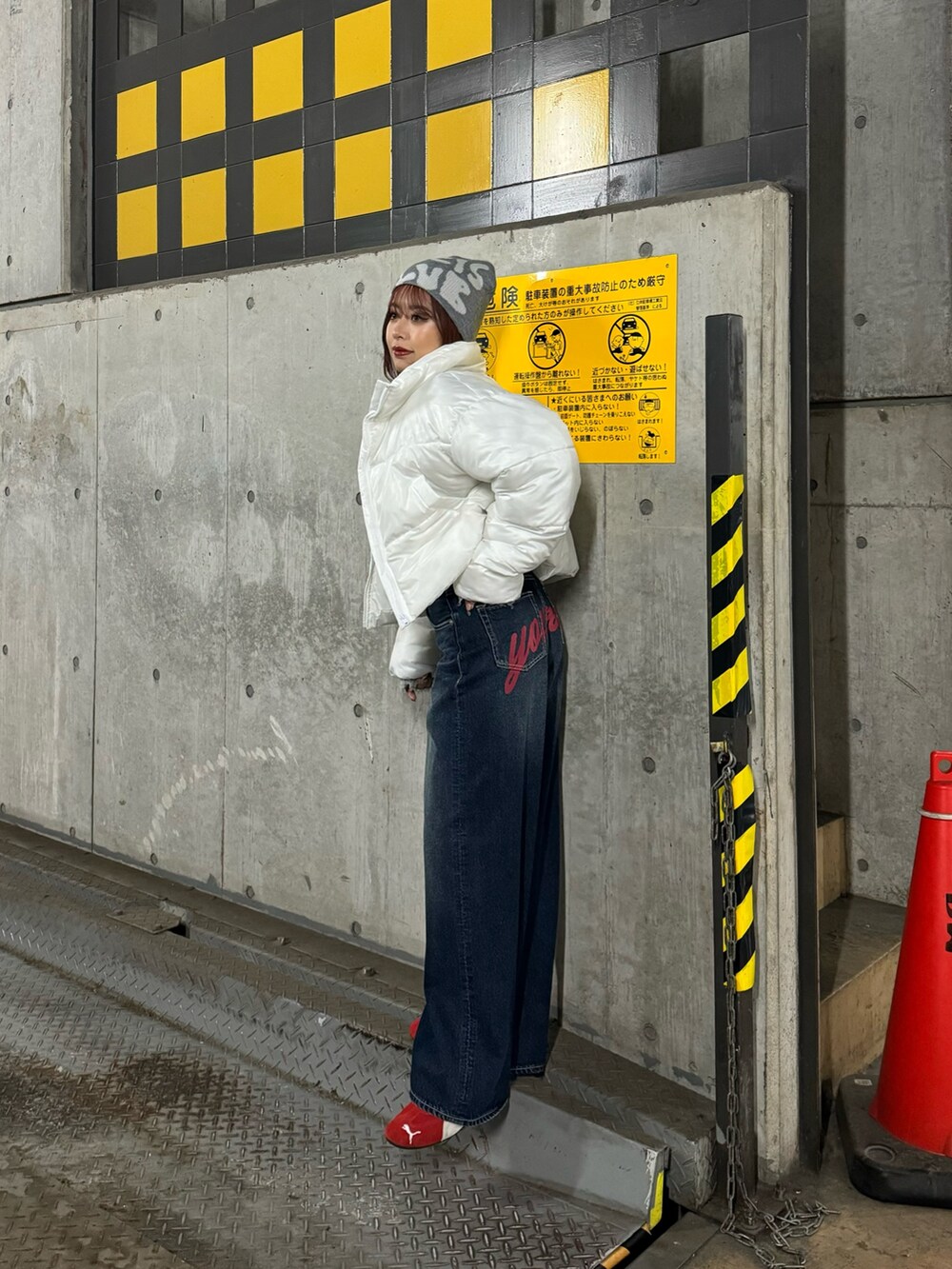 グレー系のニット/セーター、ホワイト系のブルゾン、ブルー系のデニムパンツを着用したレディースの秋コーディネートの3枚目の写真