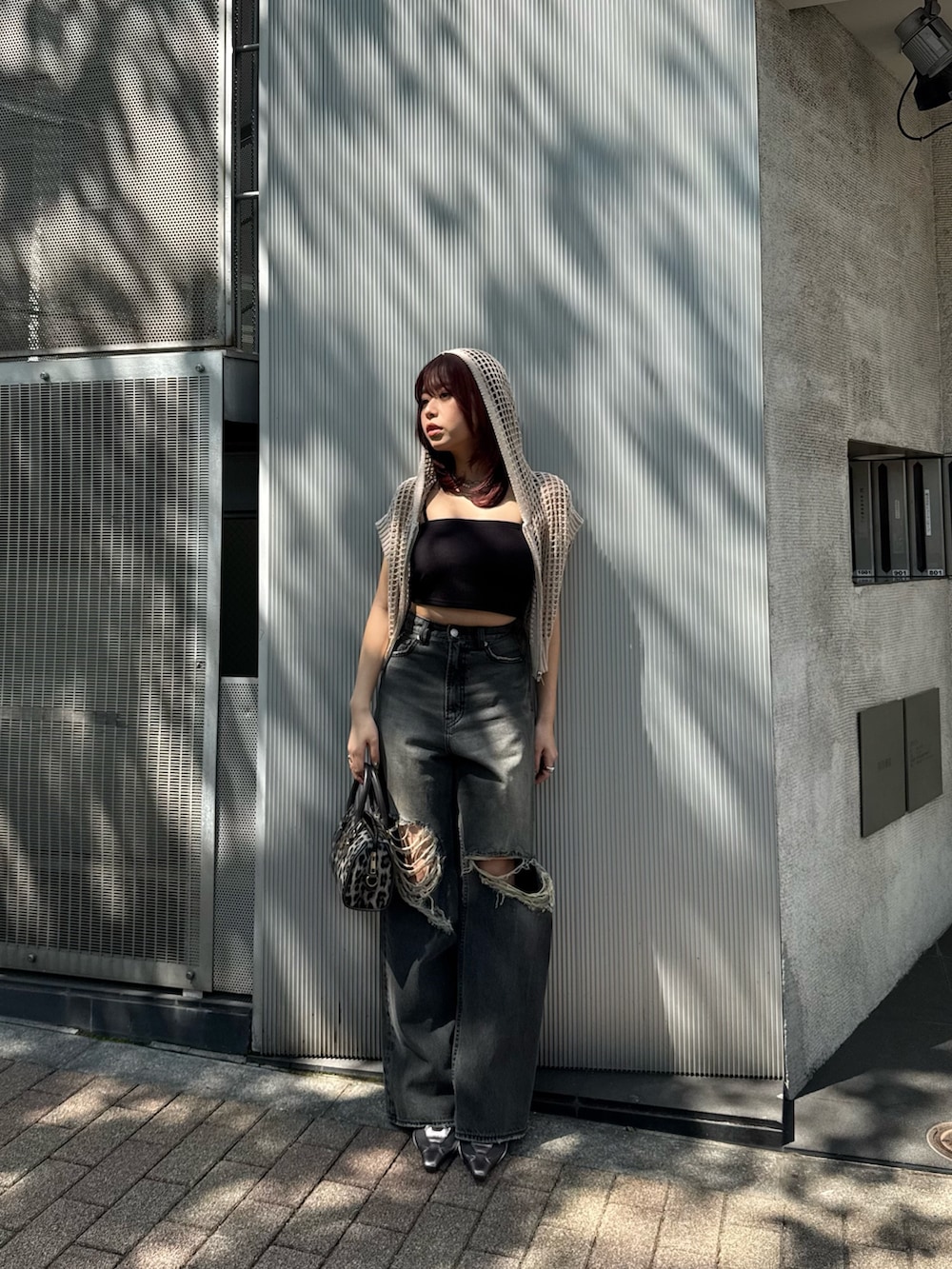 ホワイト系のニット/セーター、ブラック系のキャミソール、ブラック系のデニムパンツを着用したレディースの春コーディネートの2枚目の写真