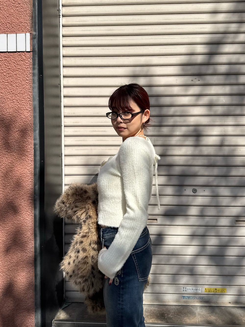 ホワイト系のニット/セーター、ブルー系のデニムパンツ、ベージュ系のスリッポンを着用したレディースの秋コーディネートの5枚目の写真