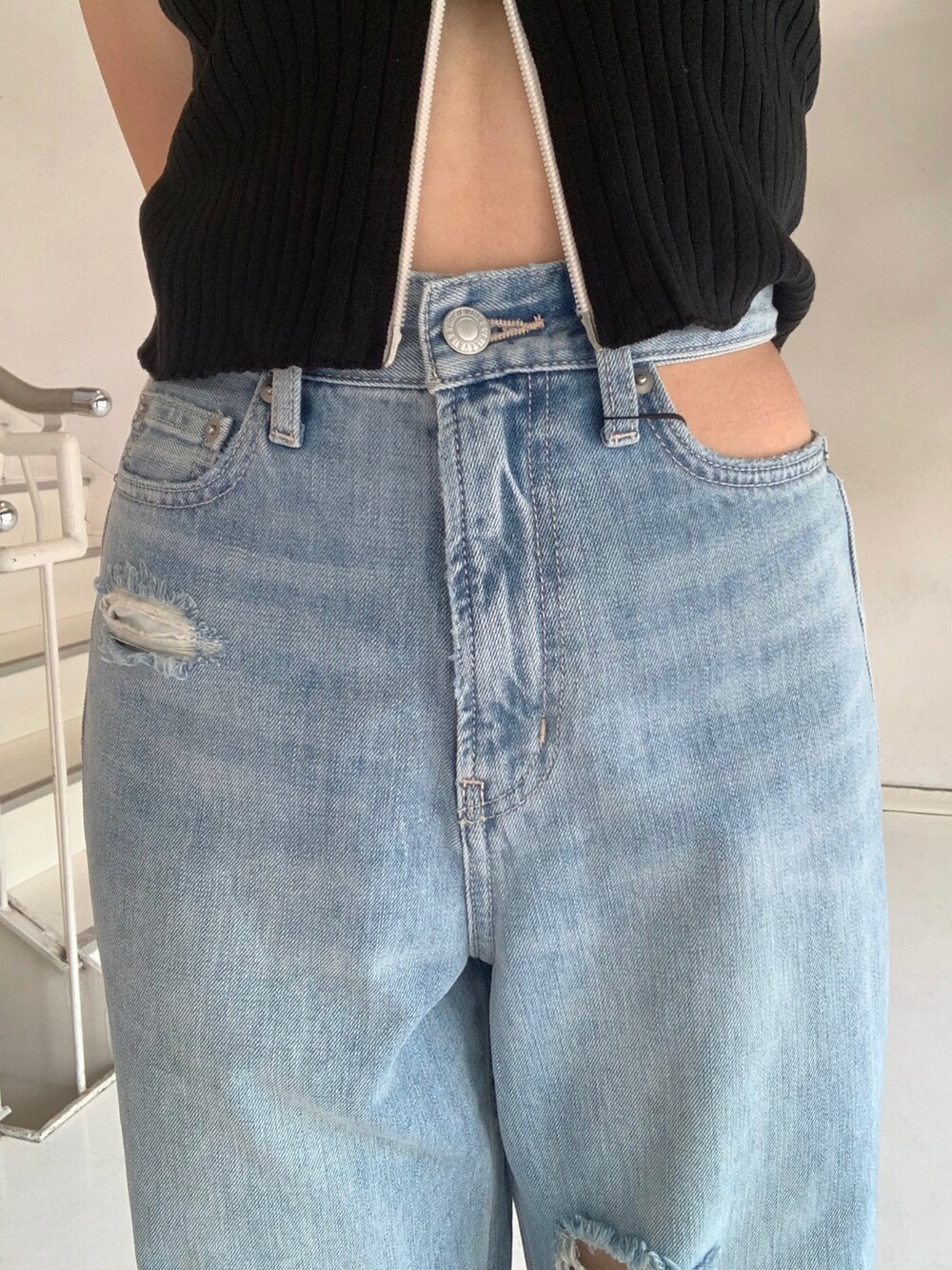 ブラック系のタンクトップ、ブルー系のデニムパンツ、オレンジ系のショルダーバッグを着用したレディースの夏コーディネートの5枚目の写真