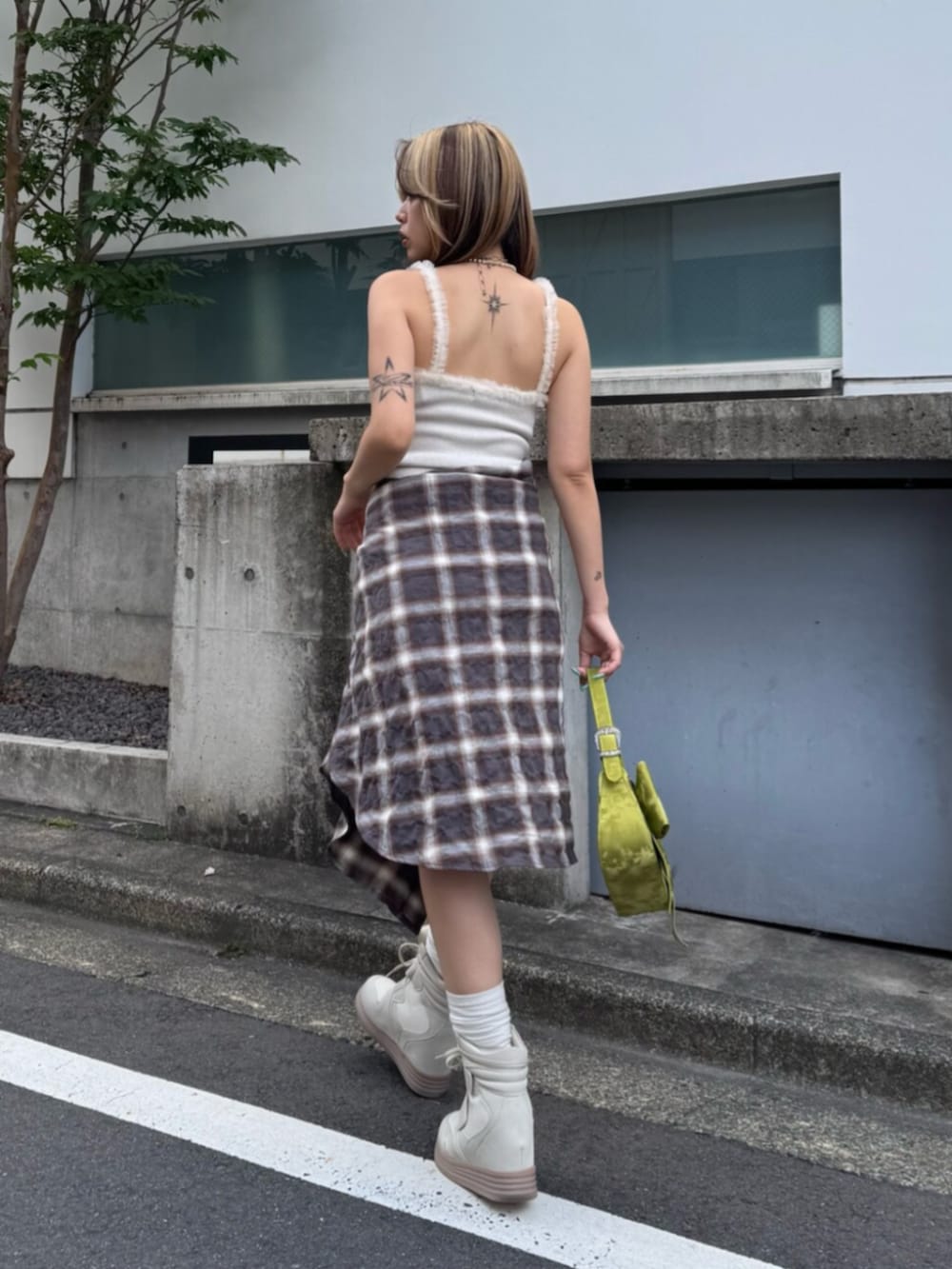 ホワイト系のワンピース、ホワイト系のスニーカー、グリーン系のハンドバッグを着用したレディースの夏コーディネートの3枚目の写真