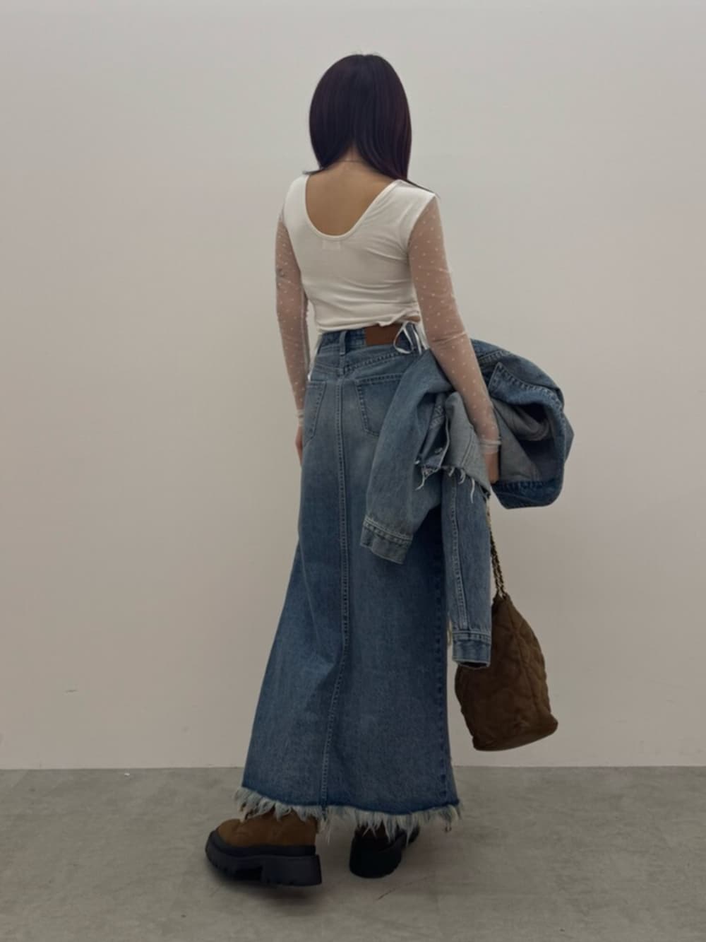 ブラウン系のショルダーバッグ、ホワイト系のTシャツ/カットソー、ブルー系のデニムスカートを着用したレディースの春コーディネートの3枚目の写真