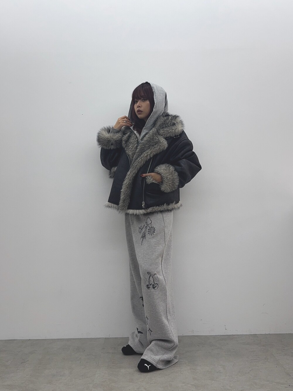 グレー系のパーカー、ブラック系のブルゾン、グレー系のスウェットパンツを着用したレディースの秋コーディネートの2枚目の写真