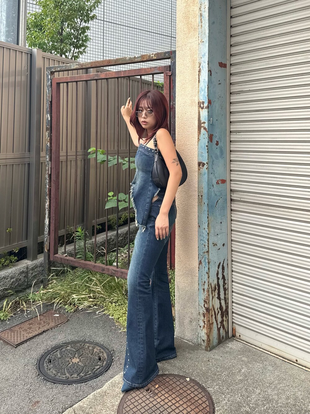 ブルー系のキャミソール、ブルー系のデニムパンツ、ブルー系のパンプスを着用したレディースの夏コーディネートの3枚目の写真