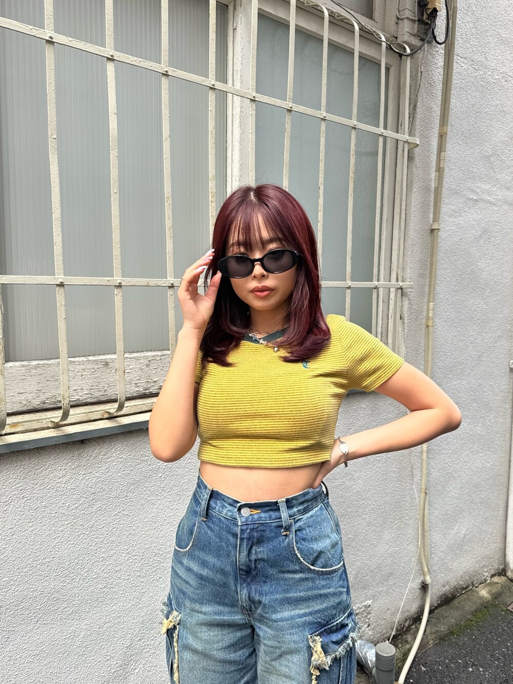 ブルー系のデニムパンツ、イエロー系のTシャツ/カットソー、ブラック系のサンダルを着用したレディースの春コーディネートの2枚目の写真