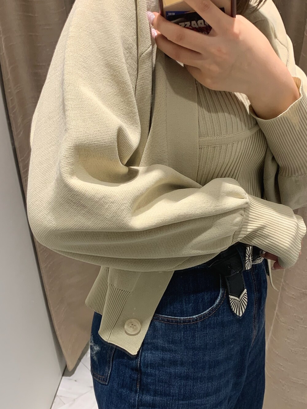 ブルー系のデニムパンツ、ホワイト系のカーディガン/ボレロ、ホワイト系のブーツを着用したレディースの冬コーディネートの4枚目の写真