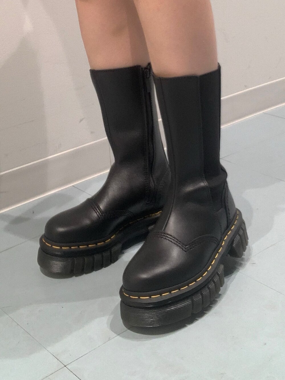 ブルー系のブルゾン、ブルー系のデニムスカート、ブラック系のブーツを着用したレディースの秋コーディネートの7枚目の写真