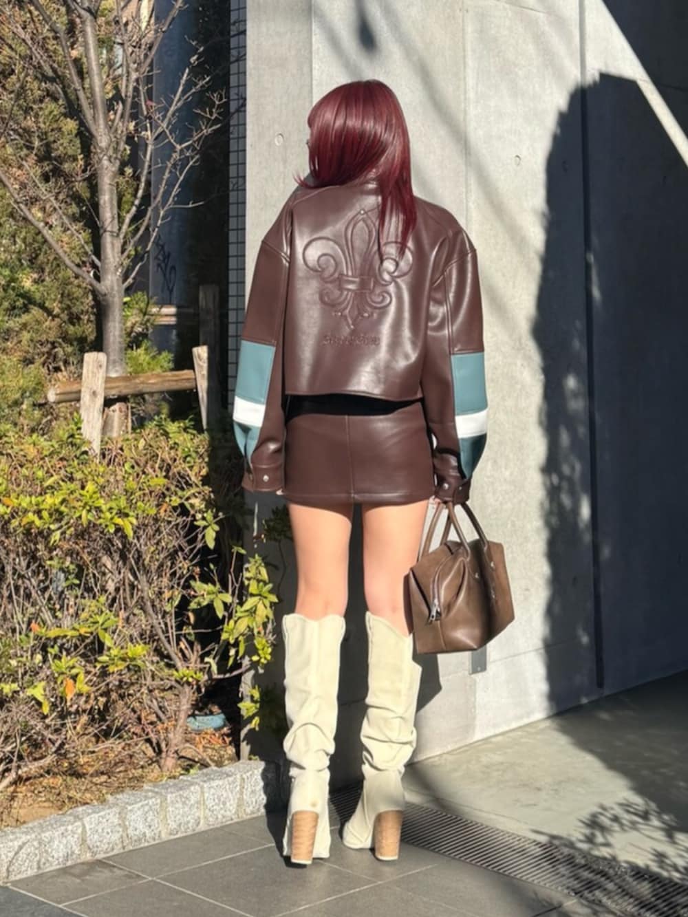 ベージュ系のシャツ/ブラウス、ブラウン系のボストンバッグ、ホワイト系のブーツを着用したレディースの冬コーディネートの4枚目の写真