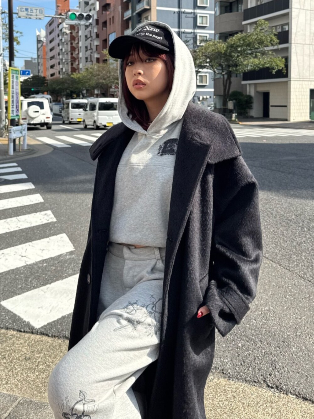 グレー系のスウェットパンツ、グレー系のパーカー、ブラック系のチェスターコートを着用したレディースの秋コーディネートの4枚目の写真