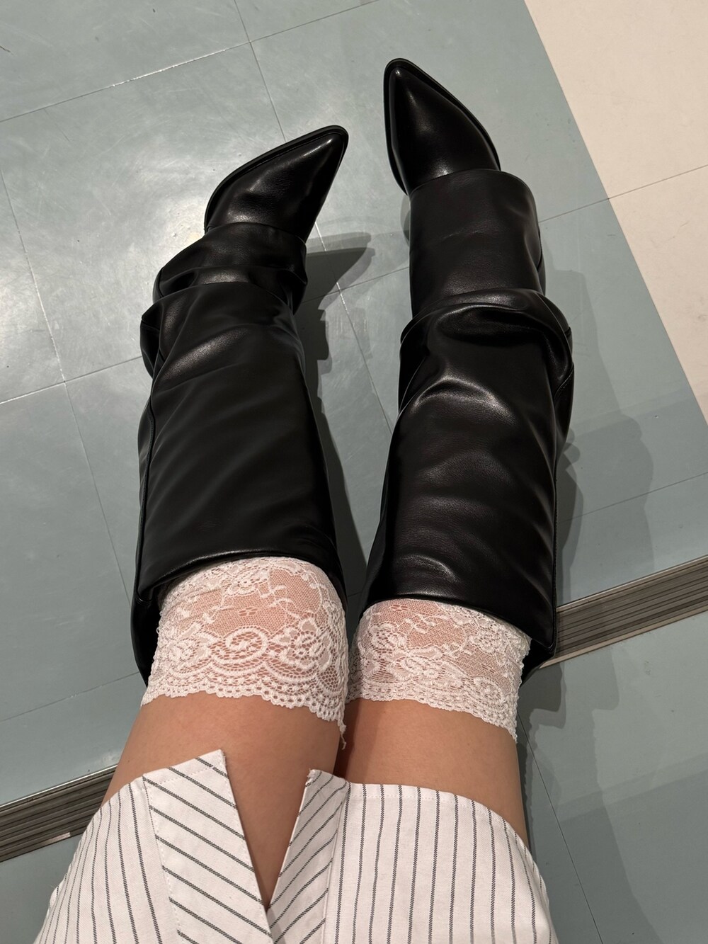 ホワイト系のシャツ/ブラウス、ブラック系のブーツを着用したレディースの冬コーディネートの6枚目の写真