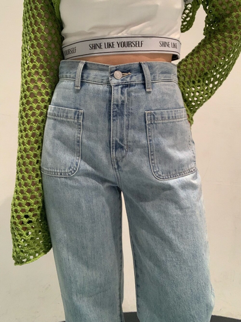 ホワイト系のサンダル、ブルー系のデニムパンツ、ホワイト系のキャミソールを着用したレディースの春コーディネートの5枚目の写真