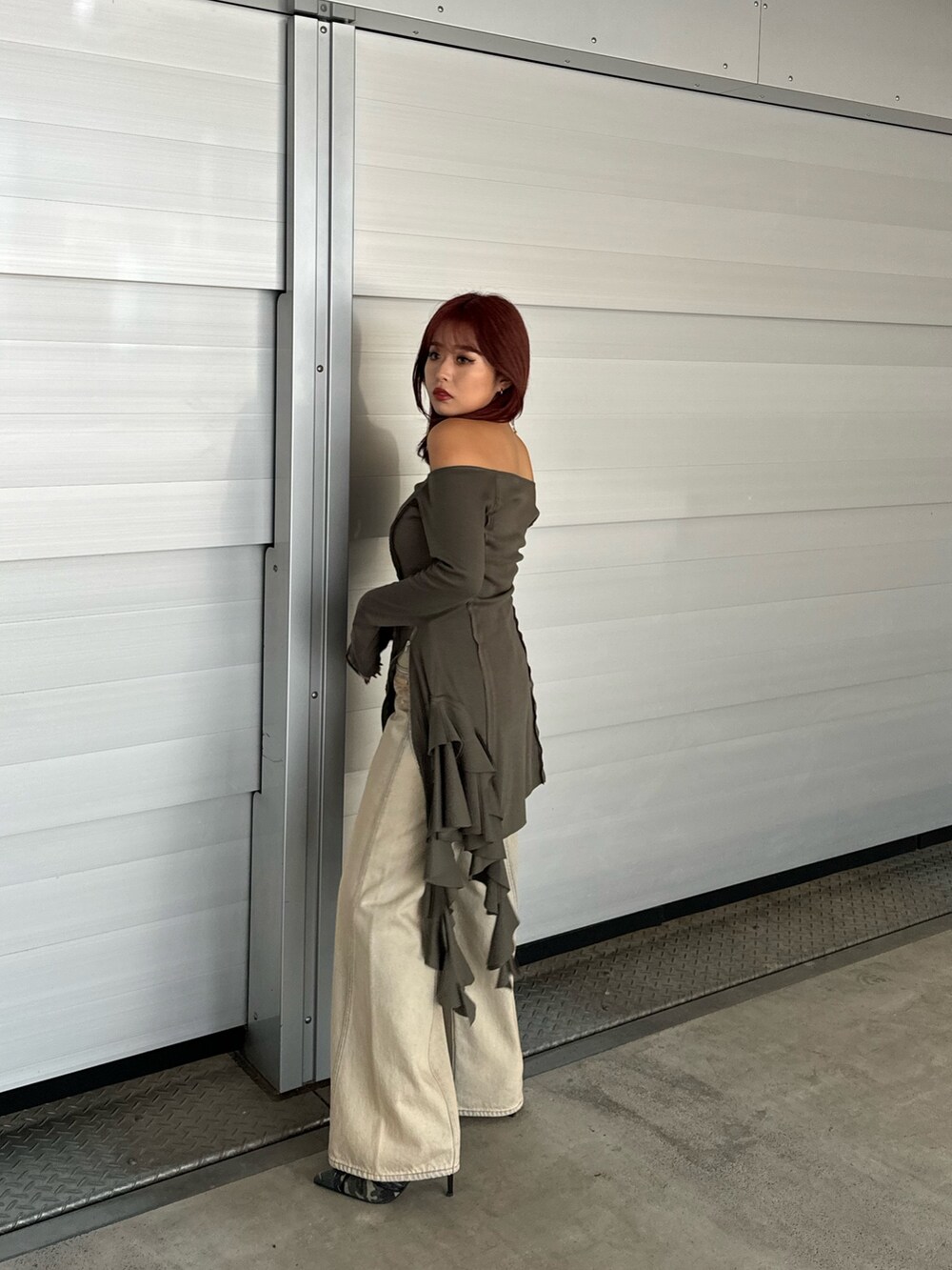 グリーン系のワンピース、ベージュ系のデニムパンツ、グリーン系のサンダルを着用したレディースの冬コーディネートの3枚目の写真