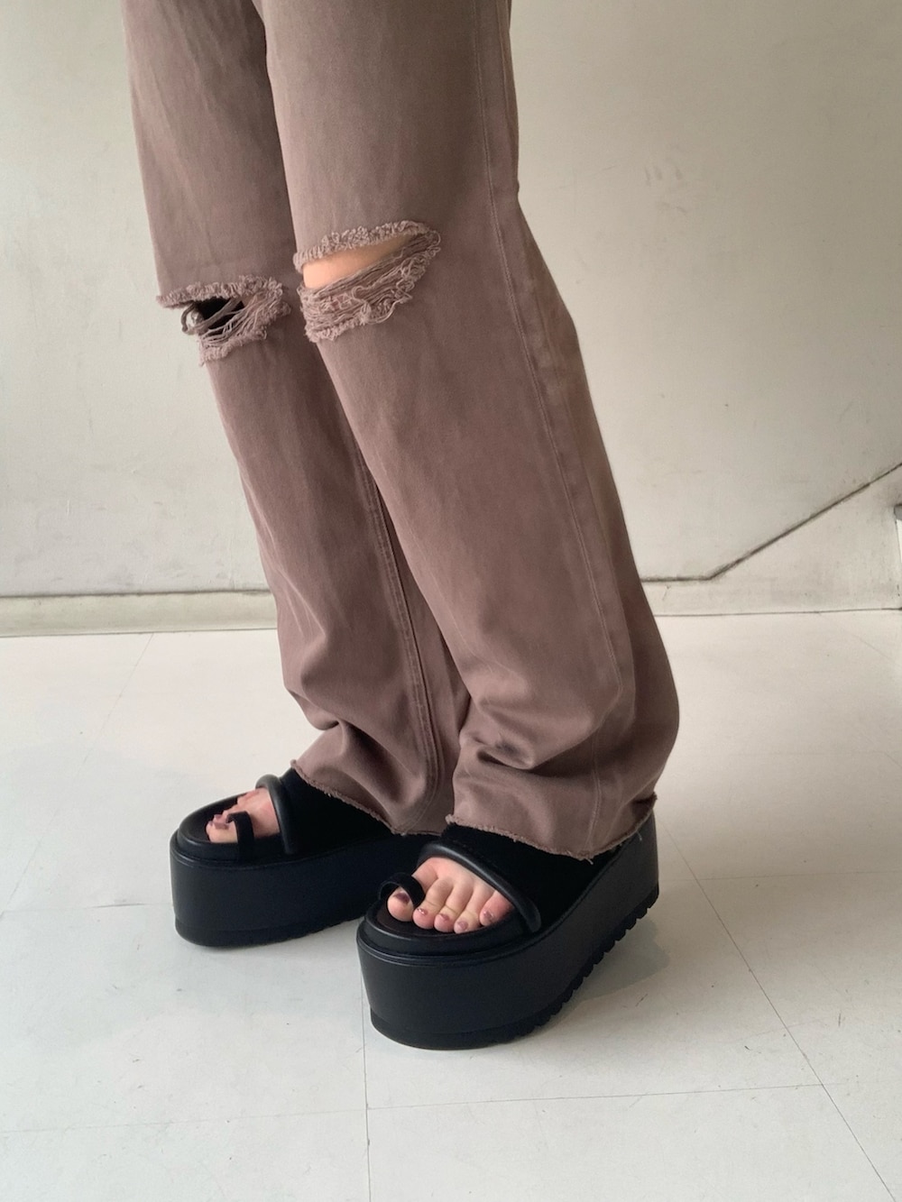 ブラック系のTシャツ/カットソー、ブラック系のサンダル、ブラウン系のデニムパンツを着用したレディースの夏コーディネートの6枚目の写真