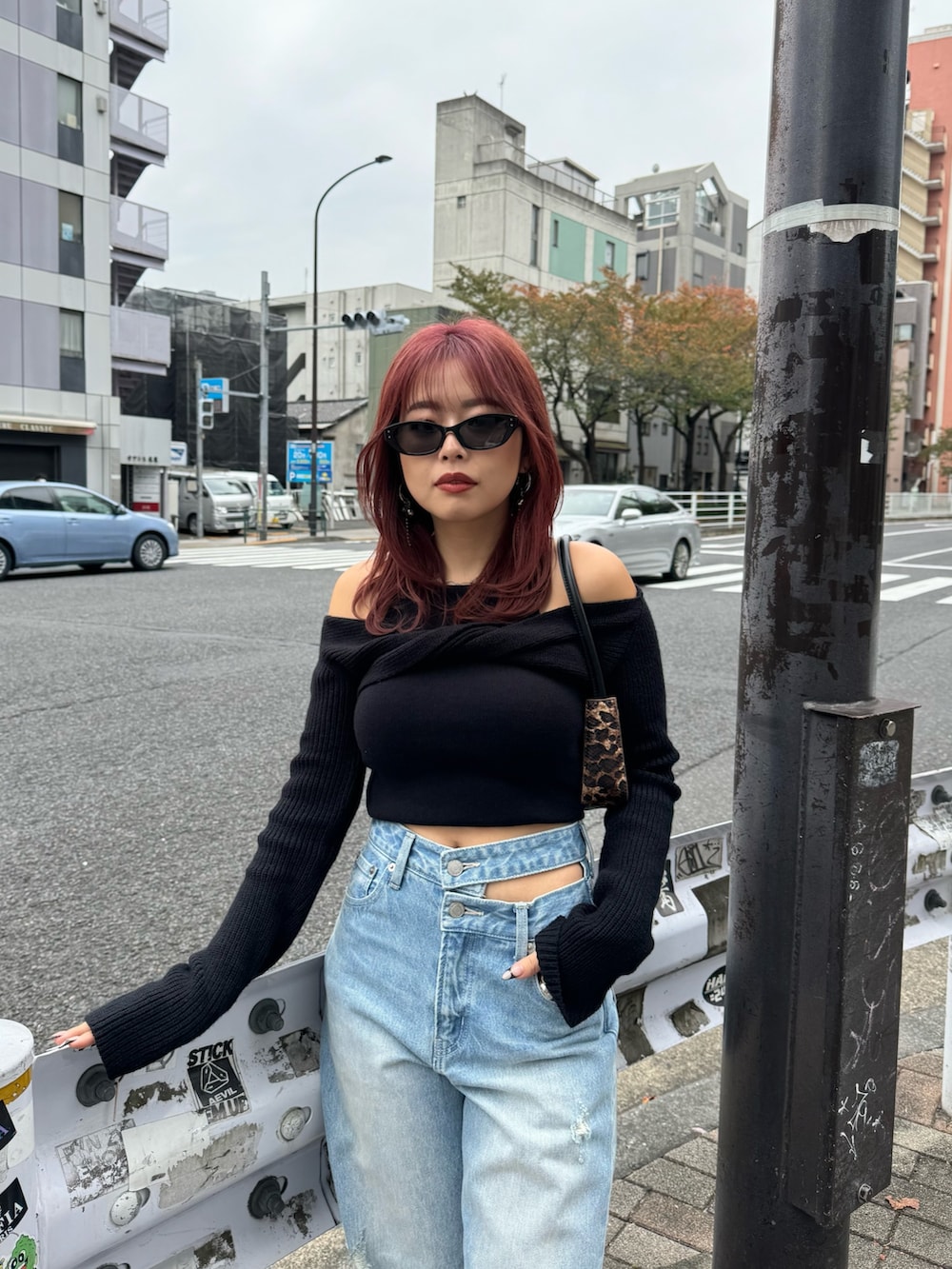 ブルー系のデニムパンツ、ブラック系のニット/セーター、レッド系のスニーカーを着用したレディースの冬コーディネートの4枚目の写真