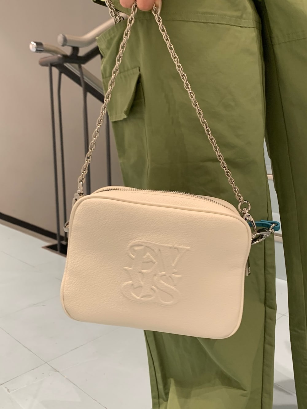 グレー系のタンクトップ、グリーン系のカーゴパンツ、ホワイト系のショルダーバッグを着用したレディースの春コーディネートの7枚目の写真