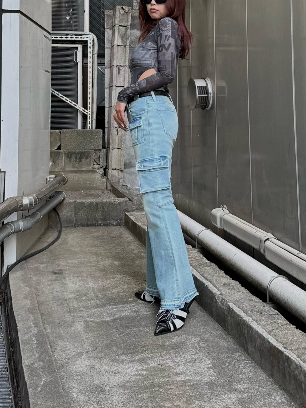 ブラック系のTシャツ/カットソー、ブルー系のデニムパンツ、ブラック系のサンダルを着用したレディースの冬コーディネートの2枚目の写真