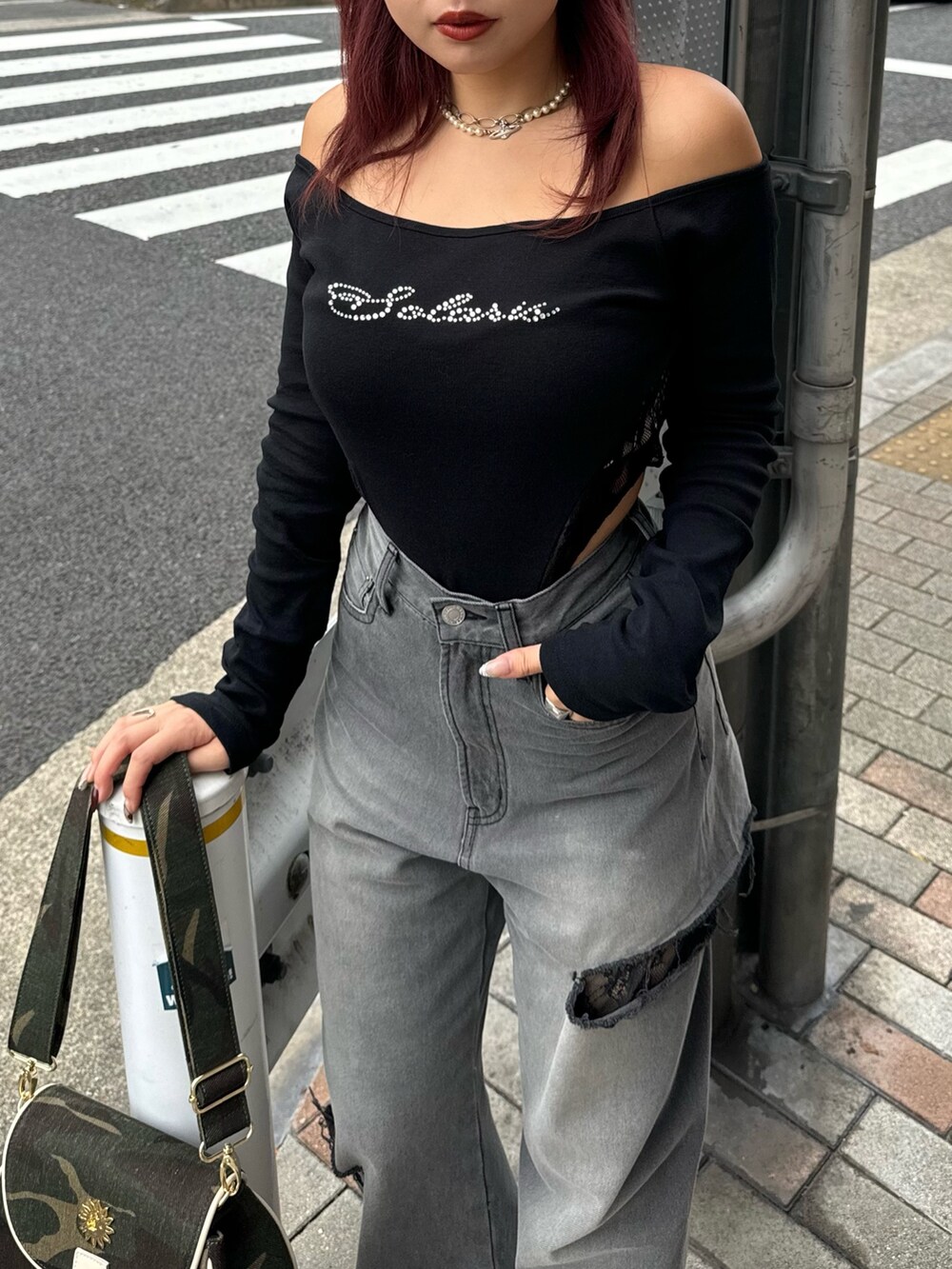 ブラック系のTシャツ/カットソー、グリーン系のショルダーバッグ、ブラック系のデニムパンツを着用したレディースの秋コーディネートの4枚目の写真