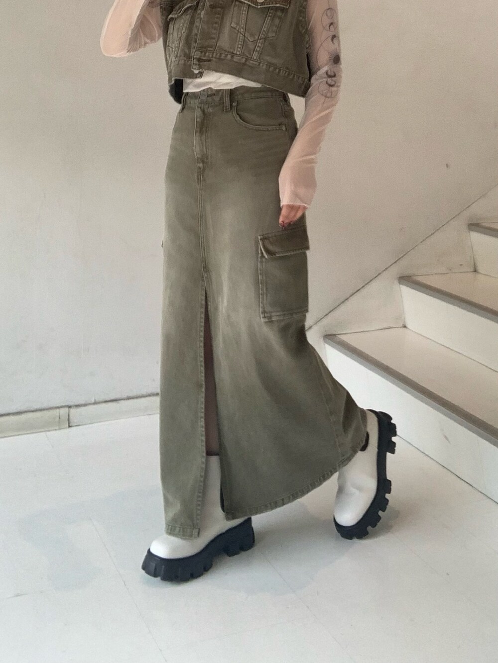 グリーン系のデニムジャケット、グリーン系のデニムスカート、ベージュ系のTシャツ/カットソーを着用したレディースの秋コーディネートの6枚目の写真