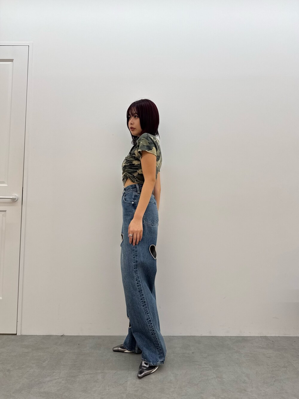 グリーン系のTシャツ/カットソー、ブルー系のデニムパンツ、シルバー系のパンプスを着用したレディースの春コーディネートの2枚目の写真