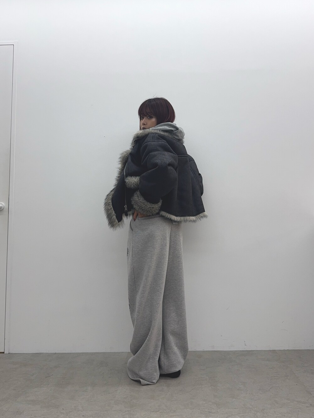 グレー系のパーカー、ブラック系のブルゾン、グレー系のスウェットパンツを着用したレディースの秋コーディネートの3枚目の写真