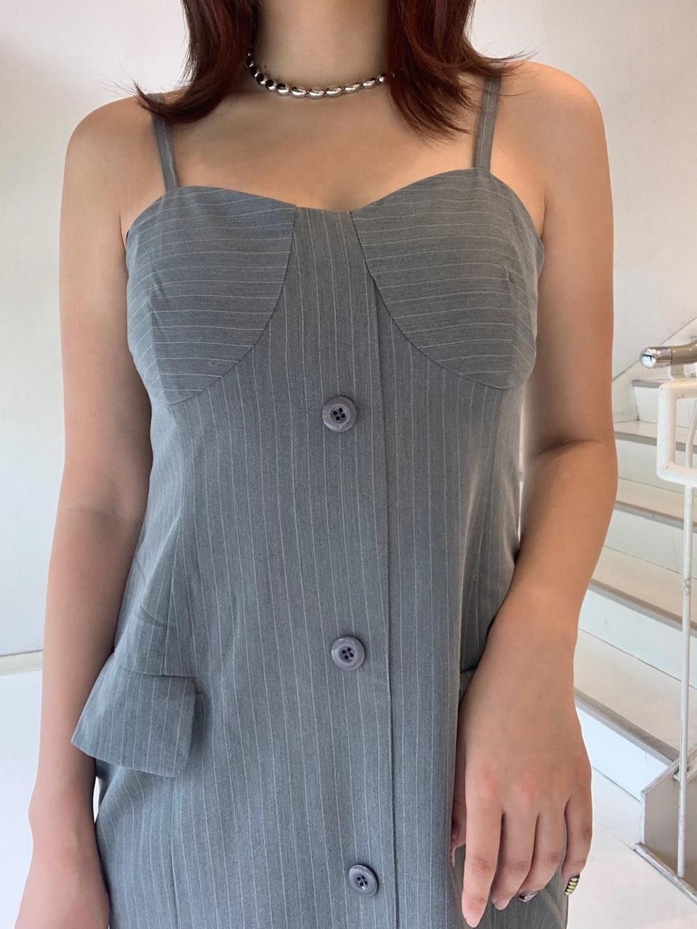 グレー系のワンピース、ブラック系のショルダーバッグ、ブラック系のブーツを着用したレディースの夏コーディネートの4枚目の写真