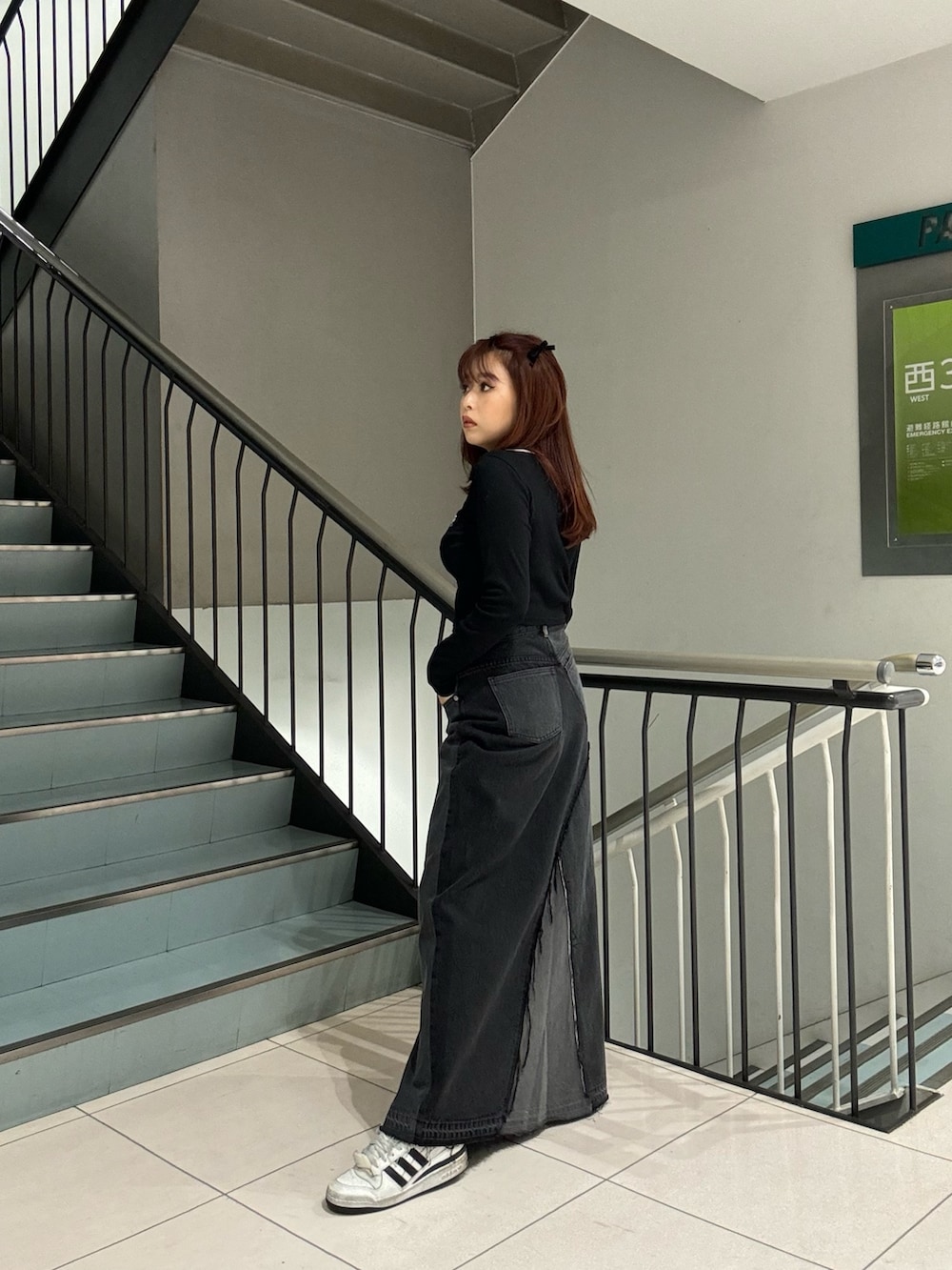 ブラック系のTシャツ/カットソー、ブラック系のデニムスカートを着用したレディースの冬コーディネートの3枚目の写真