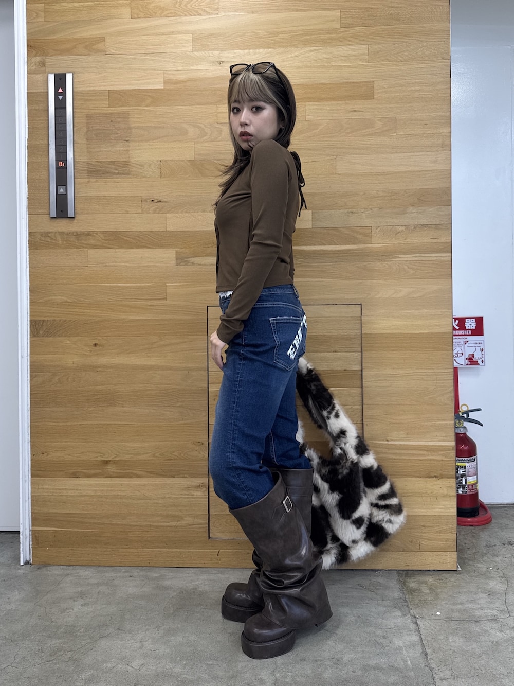 ブラウン系のTシャツ/カットソー、ブルー系のデニムパンツ、ブラウン系のブーツを着用したレディースの秋コーディネートの2枚目の写真