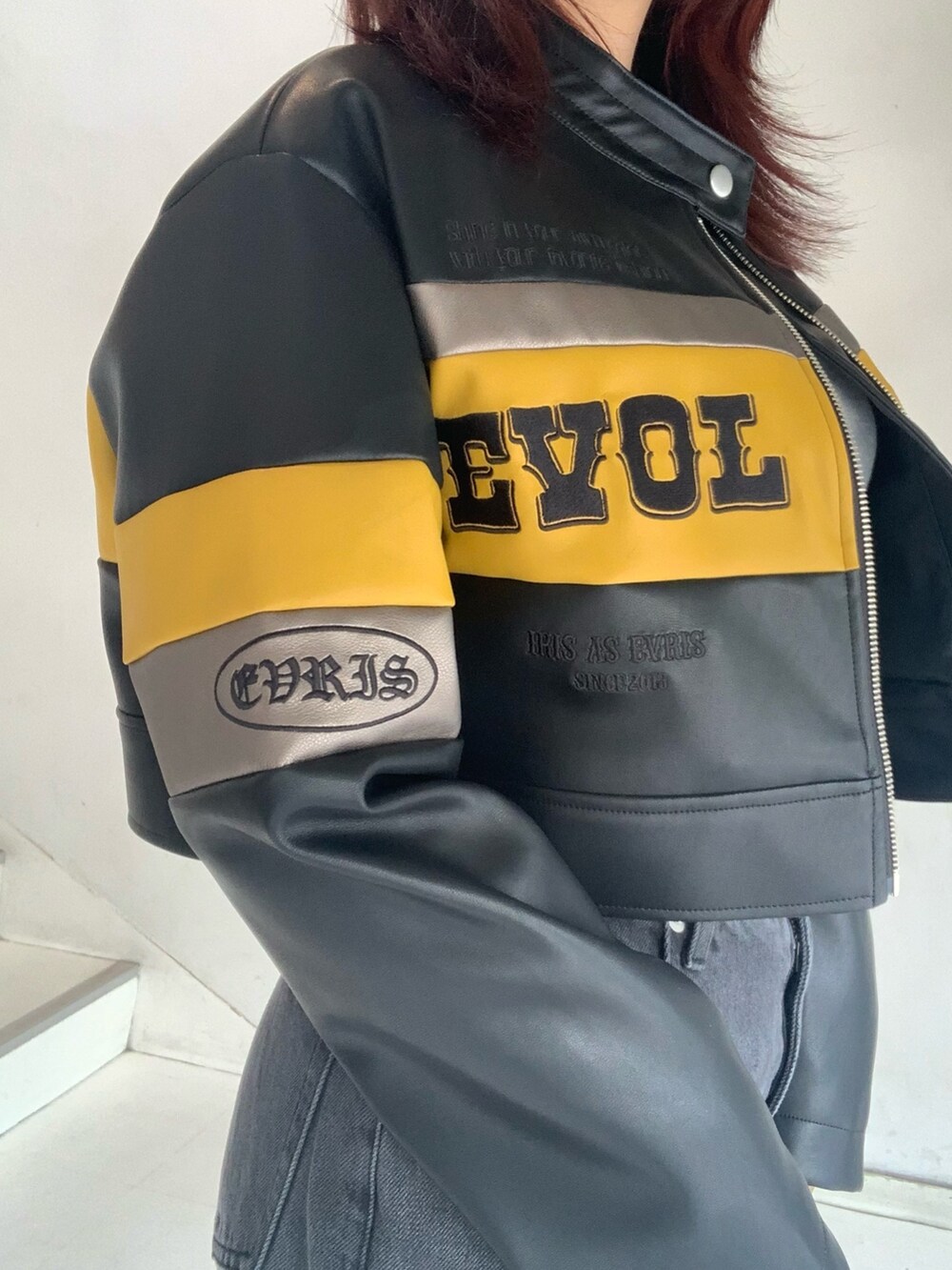 ブラック系のブルゾン、グレー系のTシャツ/カットソー、ブラック系のデニムパンツを着用したレディースの秋コーディネートの4枚目の写真