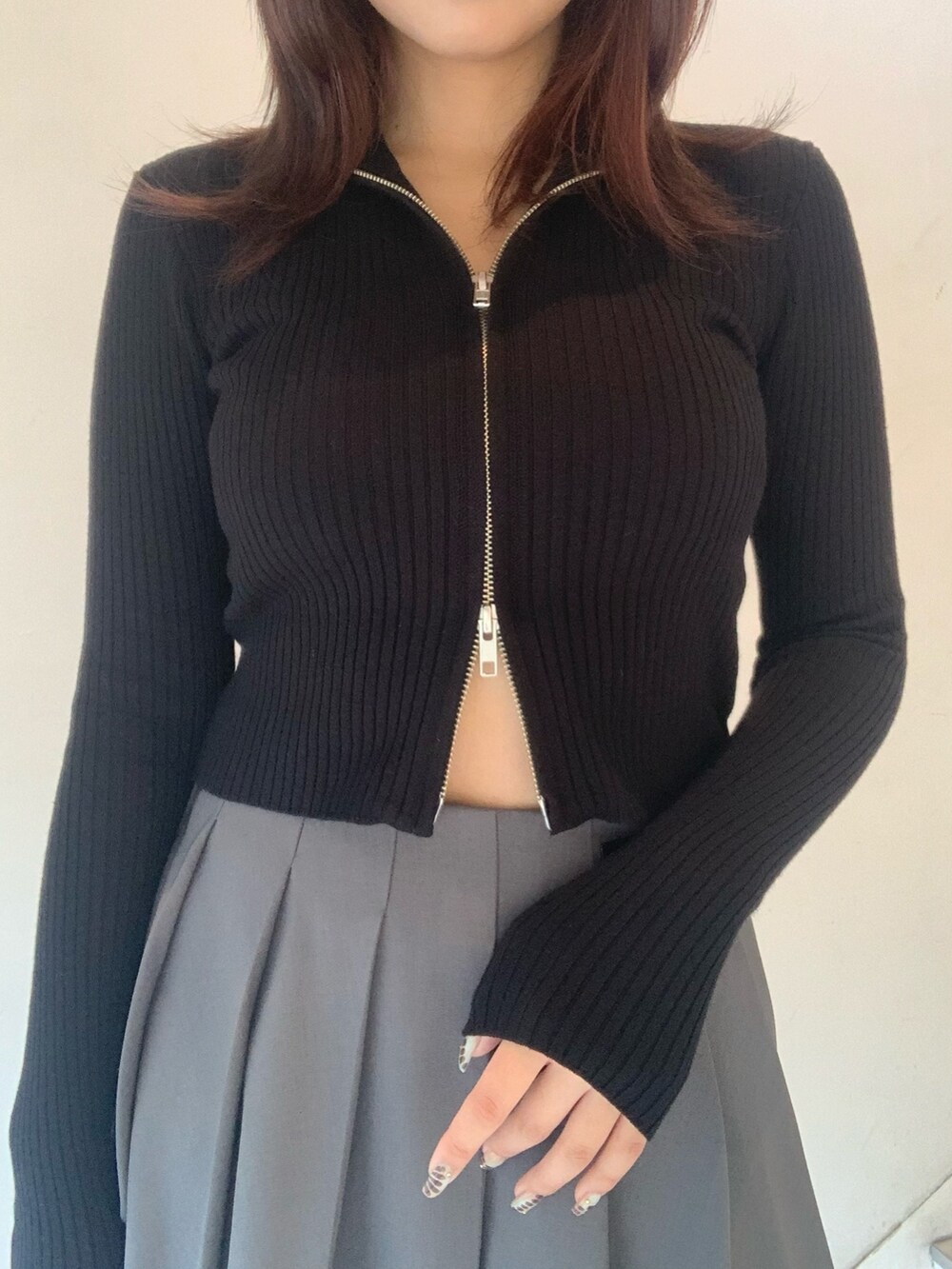 ブラック系のニット/セーター、グレー系のスカート、ブラック系のブーツを着用したレディースの秋コーディネートの4枚目の写真