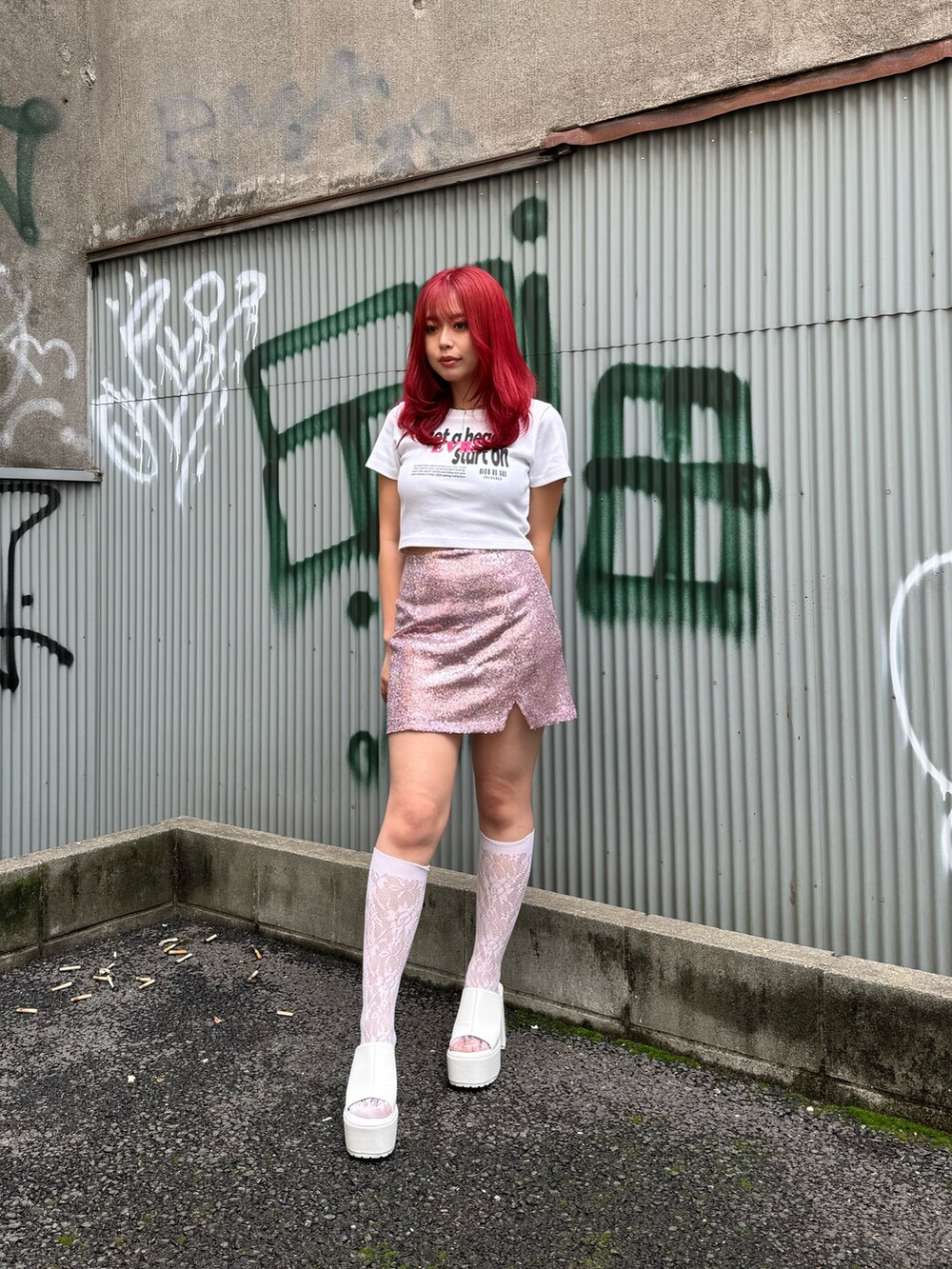 ホワイト系のTシャツ/カットソー、ピンク系のスカート、ホワイト系のサンダルを着用したレディースの春コーディネートの2枚目の写真