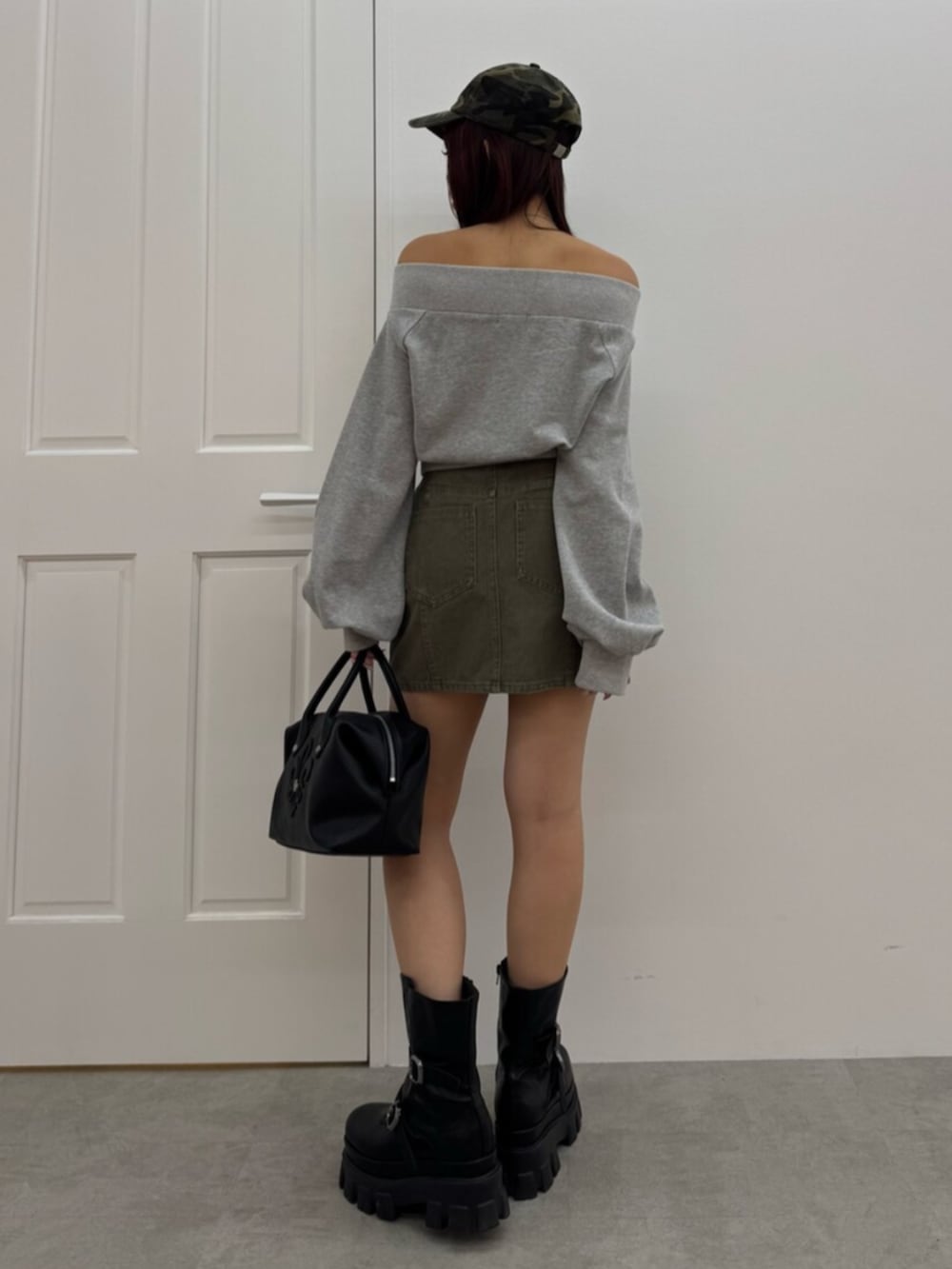 ブラック系のボストンバッグ、ブラック系のブーツ、グレー系のスウェットを着用したレディースの冬コーディネートの3枚目の写真