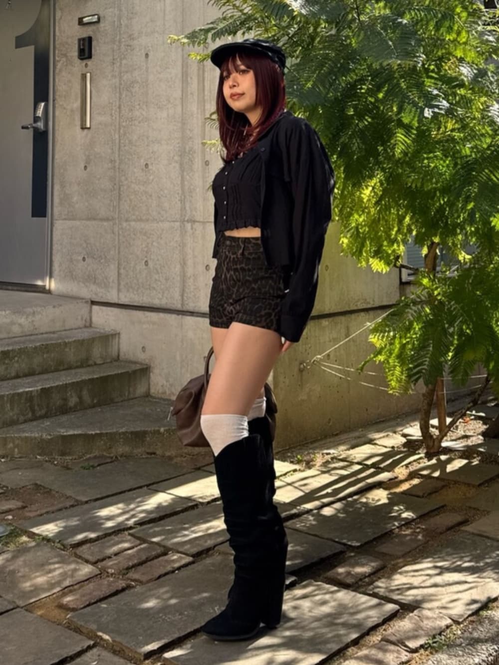 ブラウン系のボストンバッグ、ブラック系のブーツ、その他のその他パンツを着用したレディースの春コーディネートの2枚目の写真