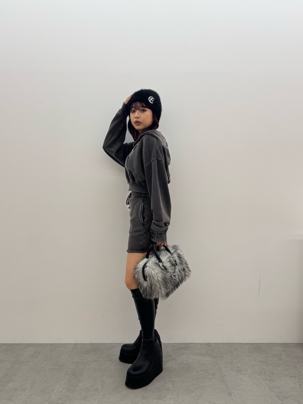 ブラック系のパーカー、ブラック系のスカート、ブラック系のボストンバッグを着用したレディースの秋コーディネートの2枚目の写真