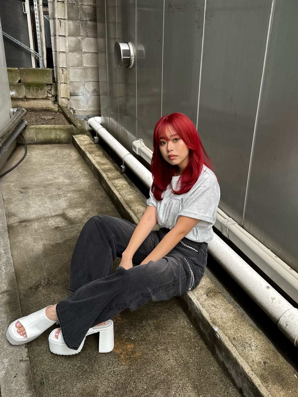 グレー系のTシャツ/カットソー、ブラック系のデニムパンツ、ホワイト系のサンダルを着用したレディースの春コーディネートの4枚目の写真