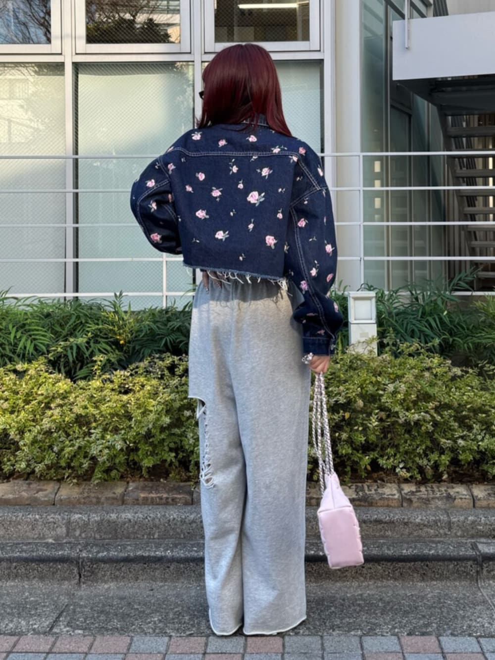 シルバー系のパンプス、グレー系のスウェットパンツ、ピンク系のショルダーバッグを着用したレディースの冬コーディネートの4枚目の写真