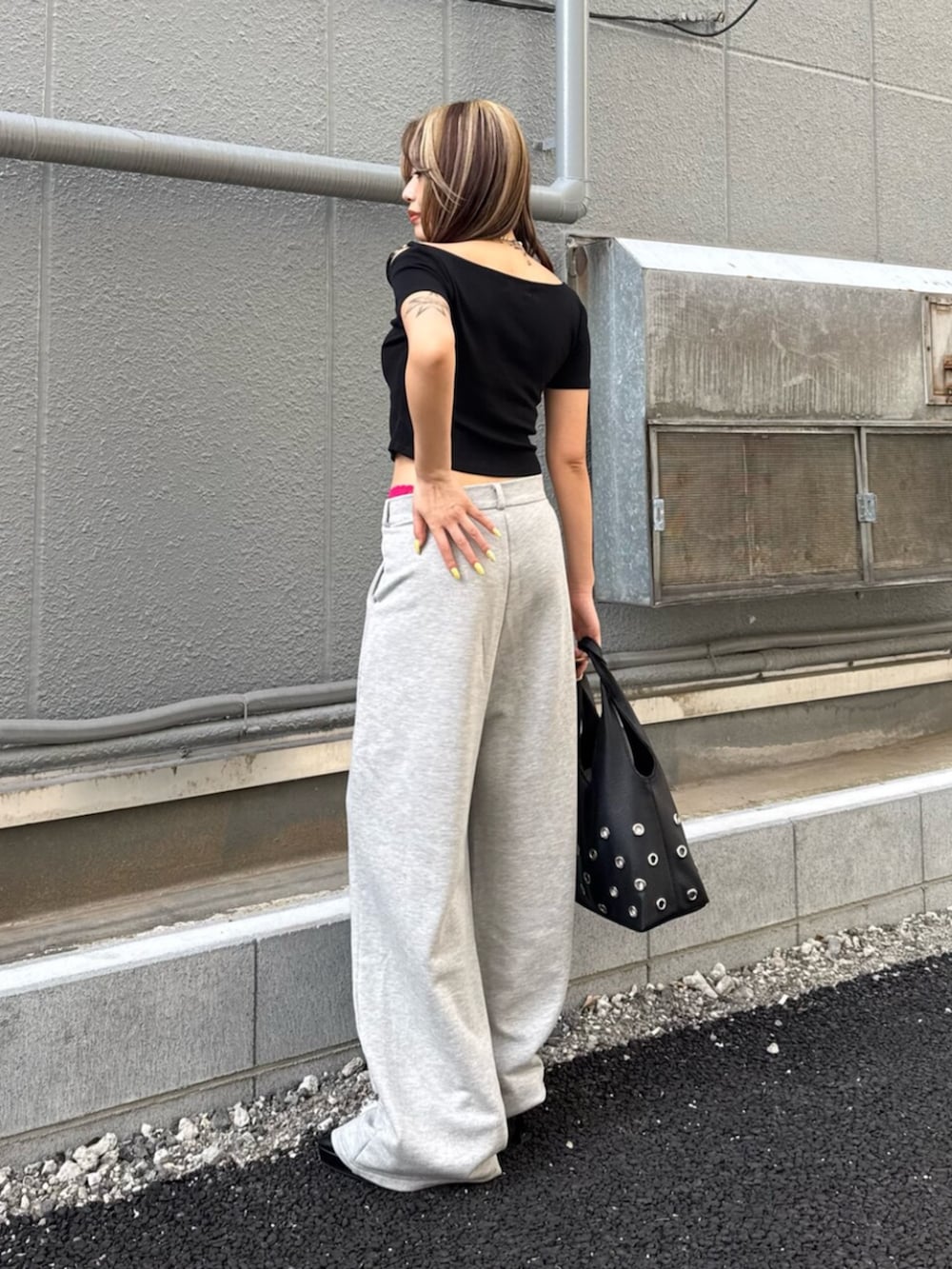 ブラック系のサンダル、ブラック系のTシャツ/カットソー、グレー系のスウェットパンツを着用したレディースの夏コーディネートの3枚目の写真