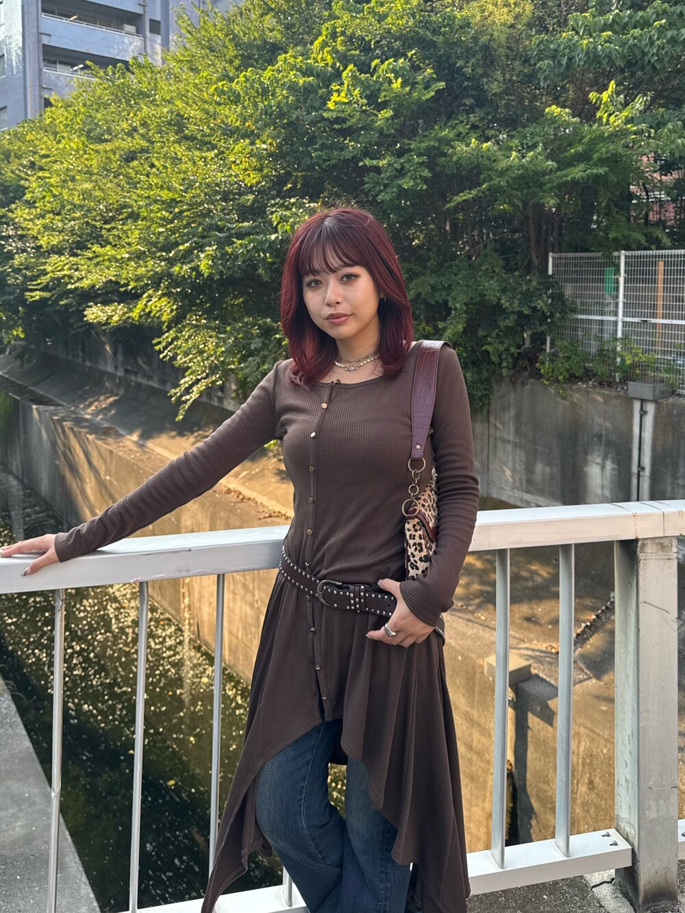 ブルー系のデニムパンツ、ベージュ系のハンドバッグを着用したレディースの秋コーディネートの6枚目の写真