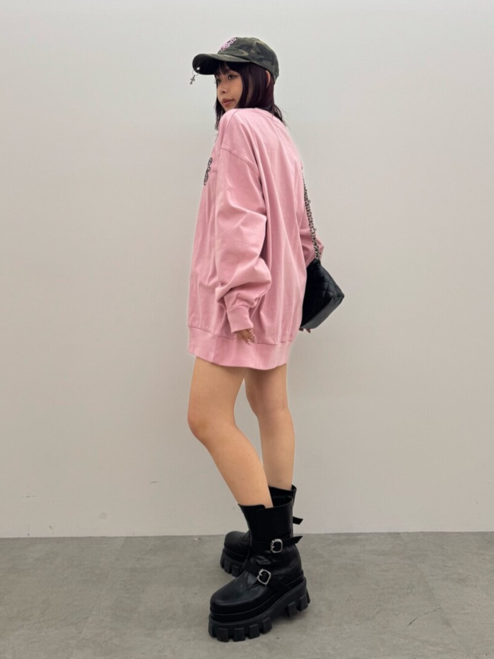 ブラック系のブーツ、ブラック系のショルダーバッグ、ピンク系のTシャツ/カットソーを着用したレディースの春コーディネートの2枚目の写真
