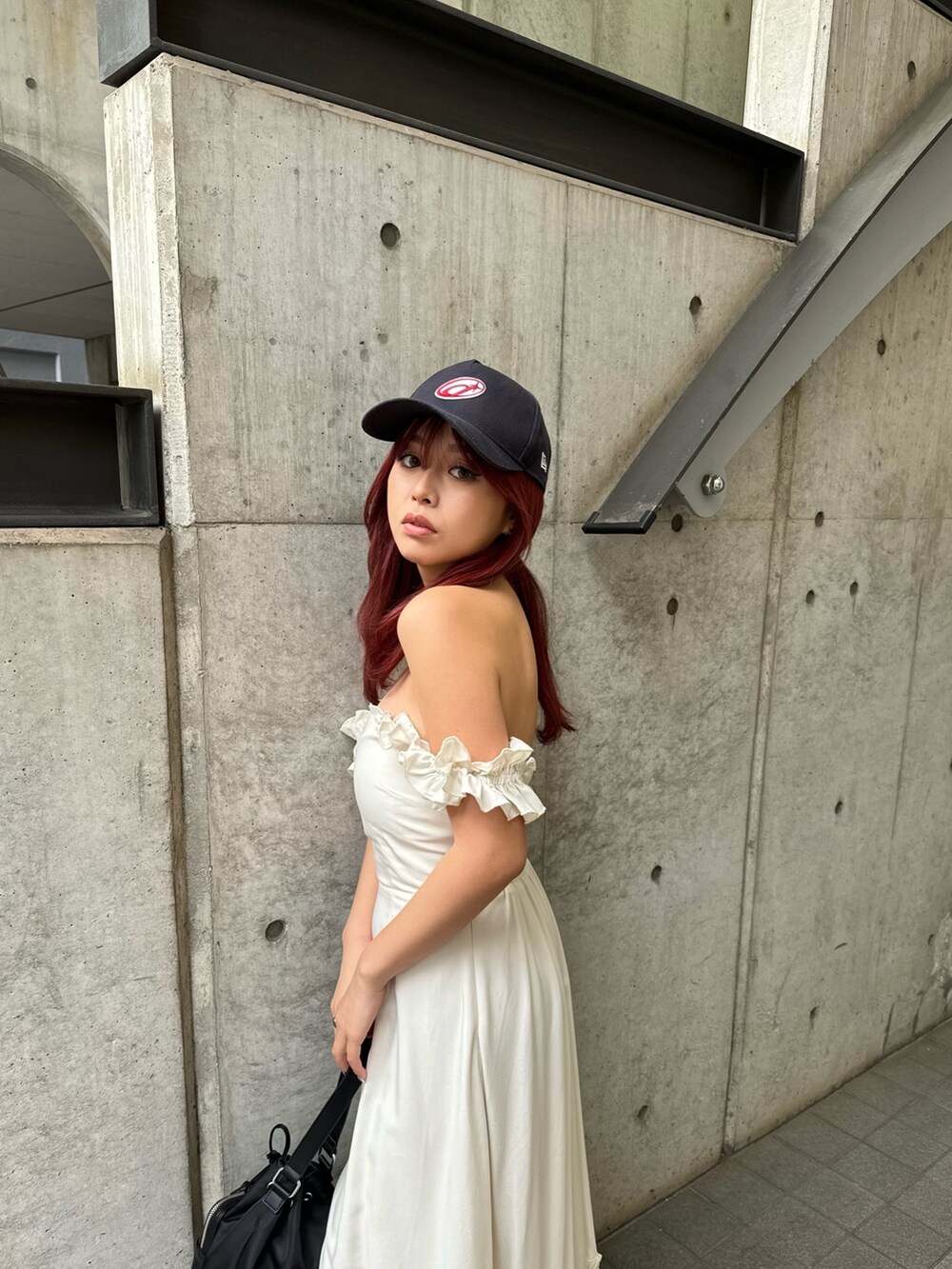 ホワイト系のワンピース、ブラック系のショルダーバッグ、ブラック系のブーツを着用したレディースの春コーディネートの4枚目の写真