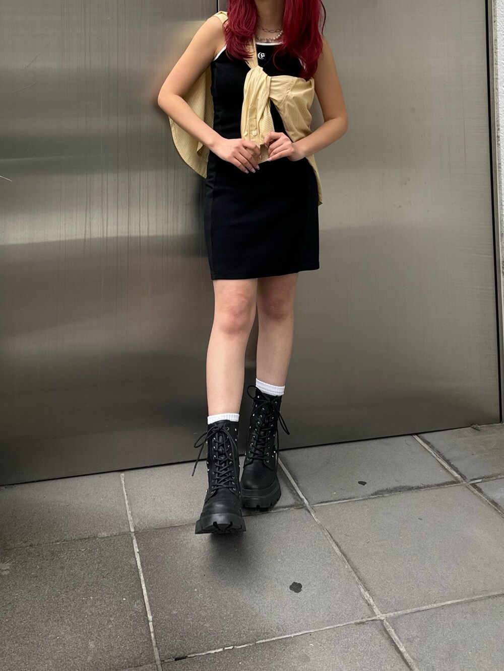 イエロー系のシャツ/ブラウス、ブラック系のワンピース、ブラック系のブーツを着用したレディースの春コーディネートの2枚目の写真