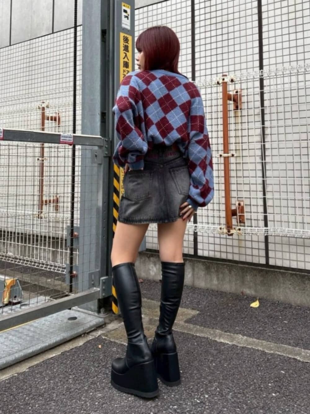 ブラック系のブーツ、ブルー系のニット/セーター、ブラック系のデニムスカートを着用したレディースの秋コーディネートの3枚目の写真