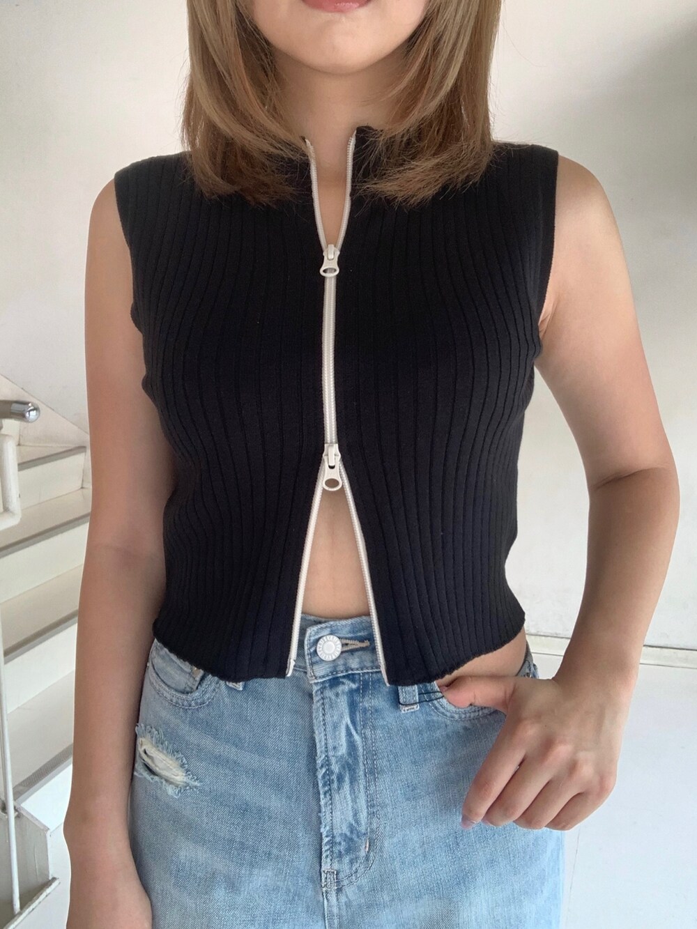 ブラック系のタンクトップ、ブルー系のデニムパンツ、オレンジ系のショルダーバッグを着用したレディースの夏コーディネートの4枚目の写真