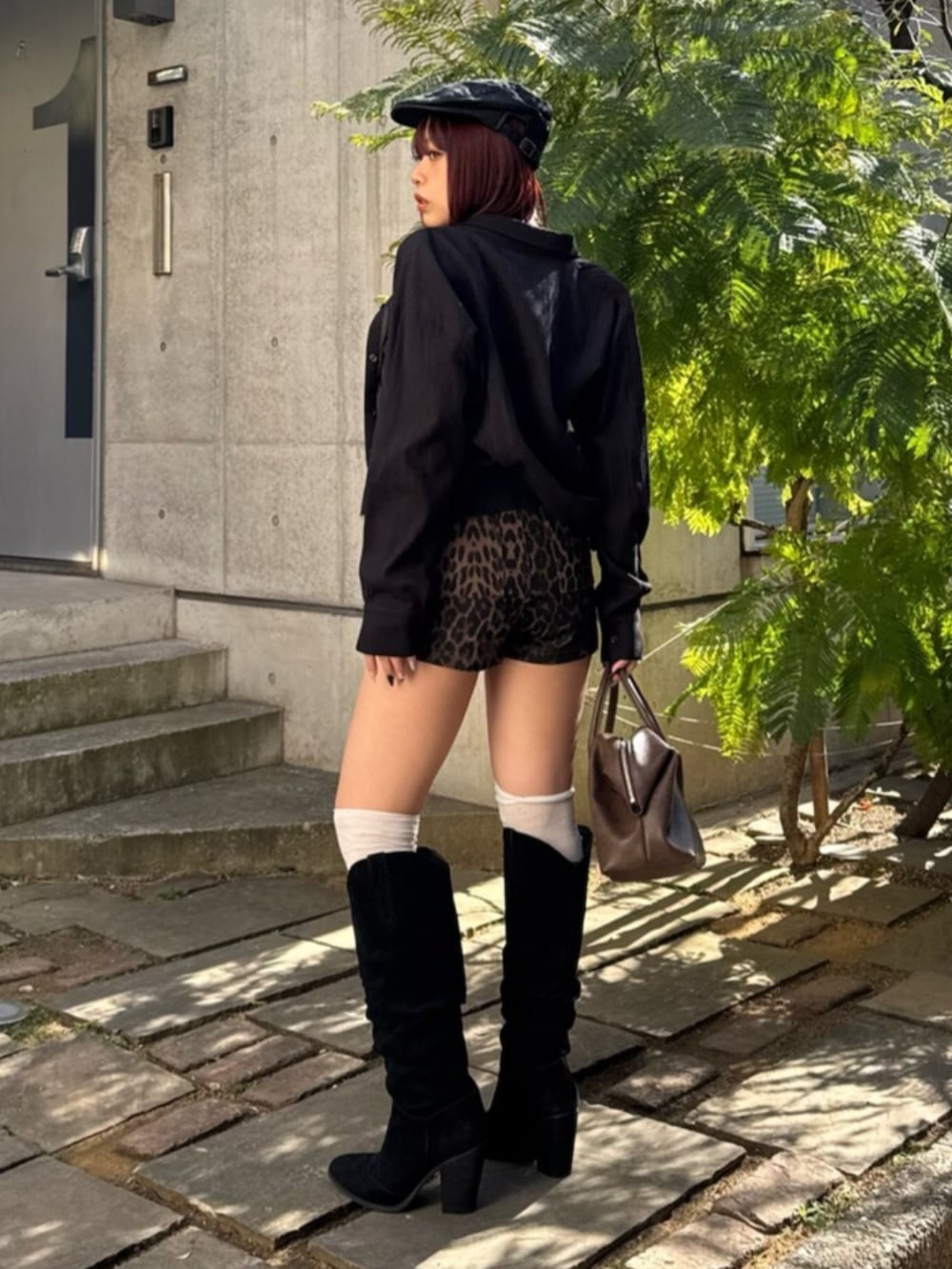 ブラウン系のボストンバッグ、ブラック系のブーツ、その他のその他パンツを着用したレディースの春コーディネートの3枚目の写真