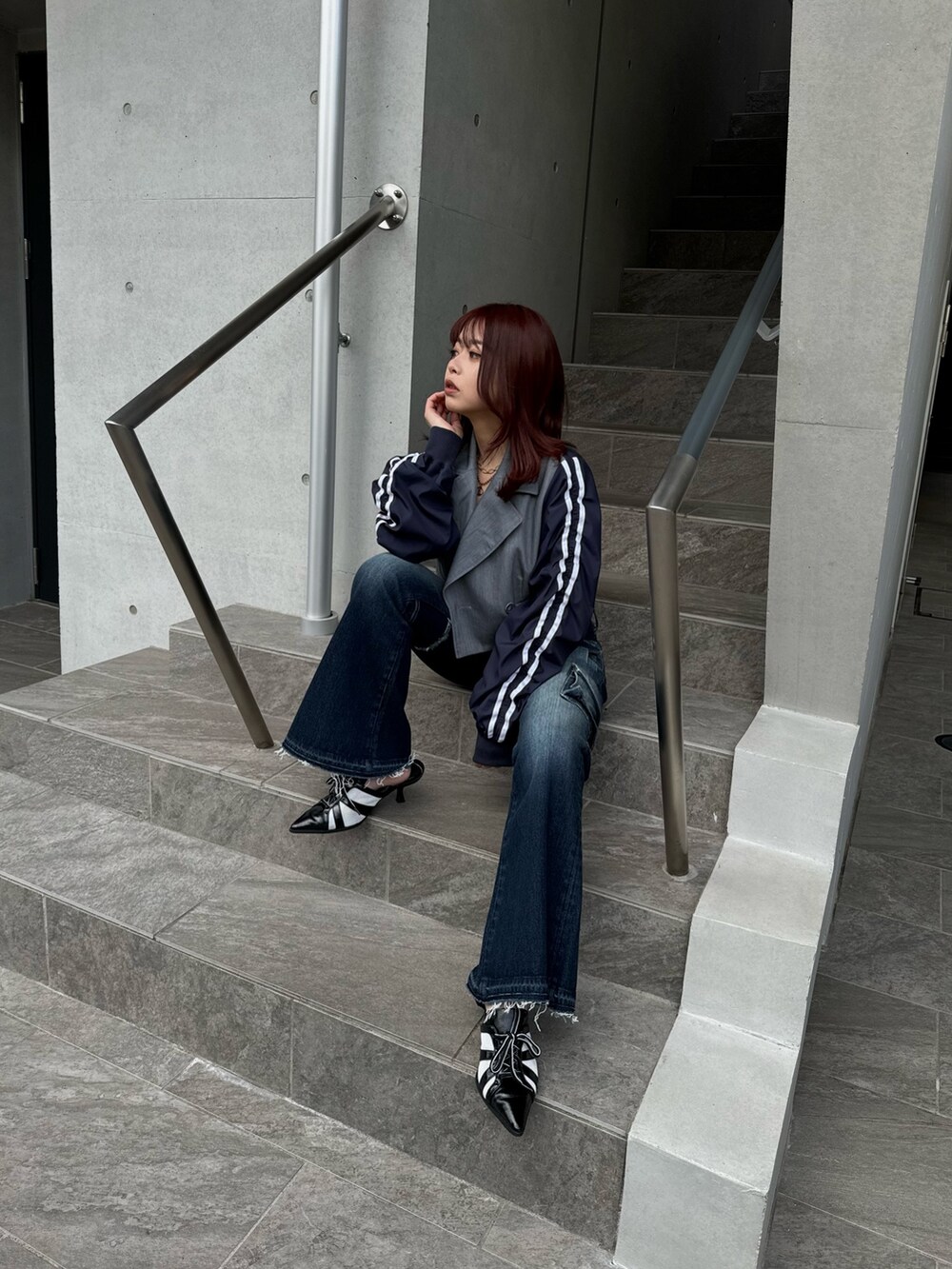 グレー系のテーラードジャケット、ブルー系のデニムパンツ、ブラック系のサンダルを着用したレディースの冬コーディネートの4枚目の写真